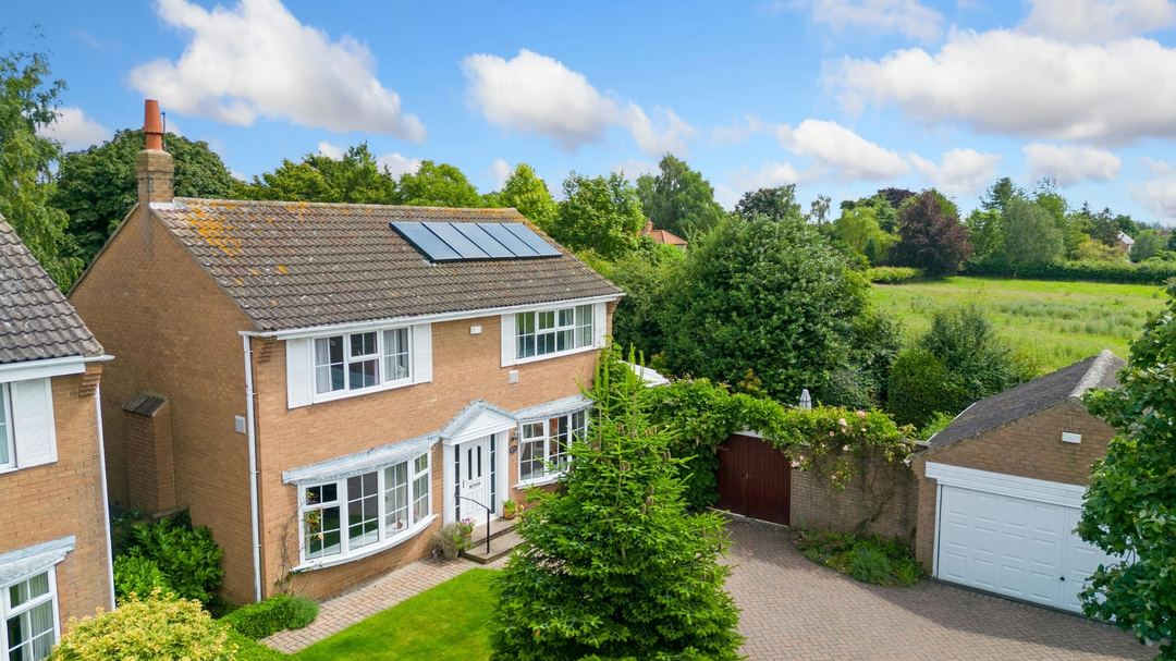 A home seen from above with fields behind